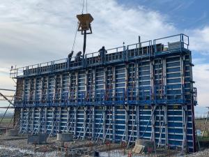 Bétonnage des murs à l’aide de la grue et de la benne à béton