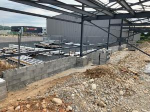 Réalisation d’un mur de soutènement et de massif en béton pour pose de la charpente métallique